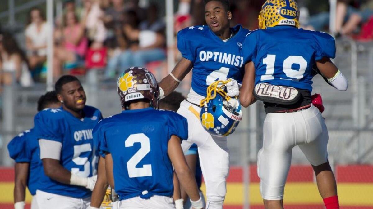 Wide receiver Tito Rocha (4) celebrates with wide receiver B.J. Brown after Brown scored a touchdown in the third quarter of the 59th Optimist All-Star Football Classic at Jesuit High School in Carmichael, Calif., on Saturday, June 18, 2016.
