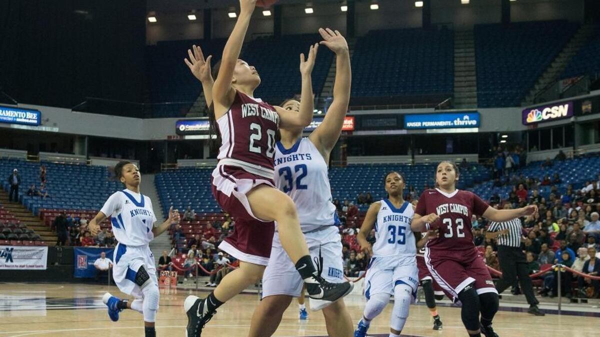 West Campus guard Iris Xiong (20) drives to the basket against Brookside Christian’s Zhane Lewis (32) during the Sac-Joaquin Section Division IV girls championship game on Saturday, March 5, 2016 at Sleep Train Arena in Sacramento.