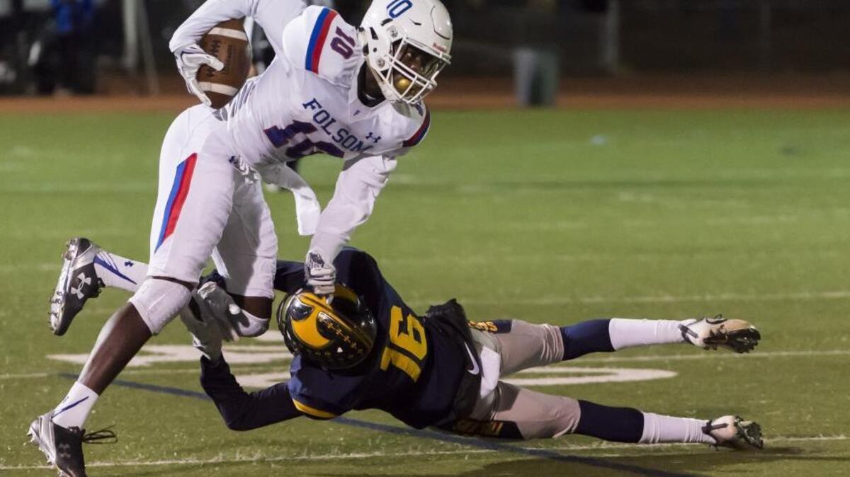 Oak Ridge Trojans’ Sawyer Merrill (16) attempts to tackle Folsom Bulldogs’ Joe Ngata (10), after his catch Friday.