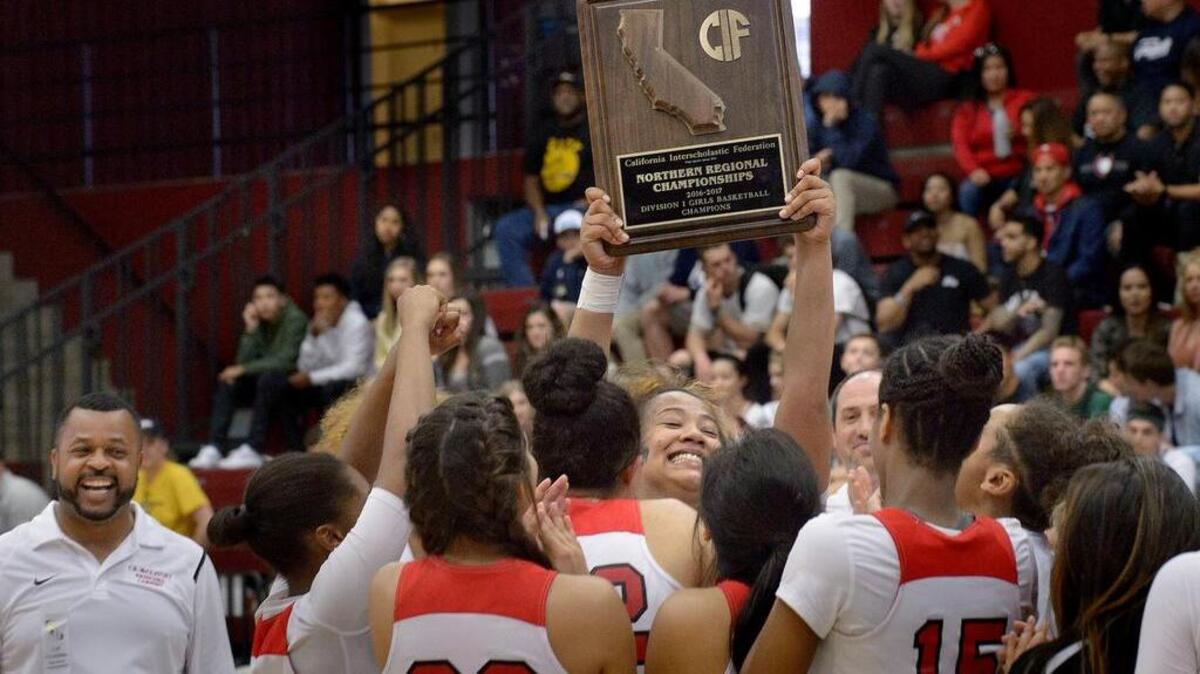 McClatchy forward Richelle Turney holds up the team’s trophy following the CIF Northern California Division I girls basketball championship game against Oak Ridge at Leavey Event Center in Santa Clara on Saturday. The Lions won 46-34.