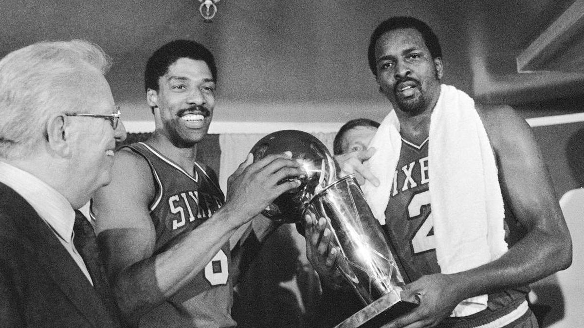 
Philadelphia 76ers Julius Erving, left, and Moses Malone, right, hold the NBA championship trophy May 31, 1983 after defeating the Los Angeles Lakers in four games. At left is Commissioner Larry O’Brien.
