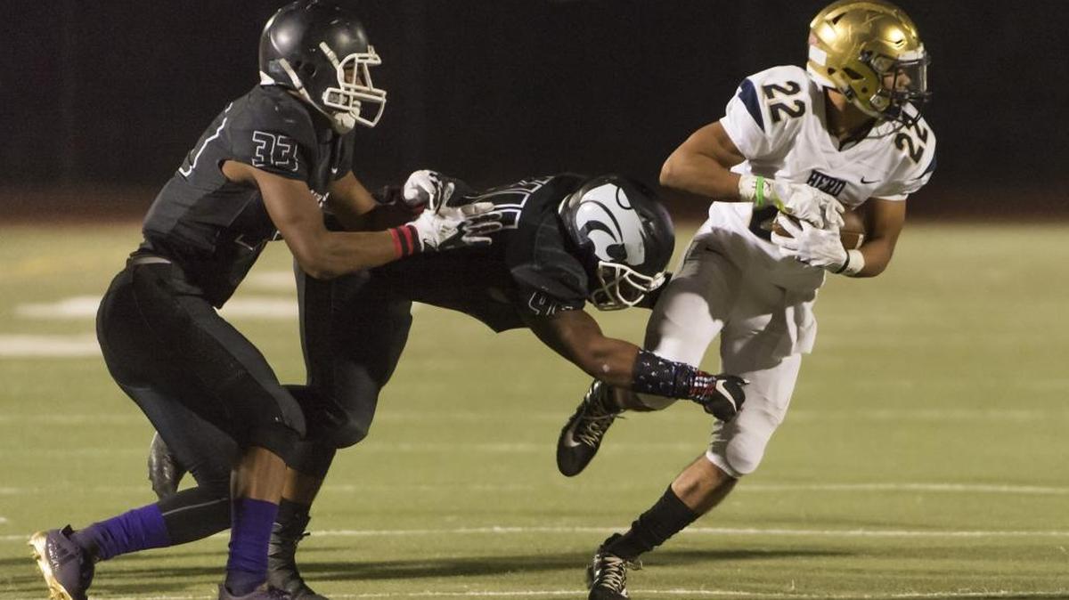 Franklin High School Wildcats Damerien Claridy (33) and John Montgomery III (44), tackle Elk Grove Thundering Herd Jaden Burns (22), during the third quarter as Elk Grove defeatd Franklin 30-26 at Cosumnes Oaks High School, Friday, Oct. 27, 2017.