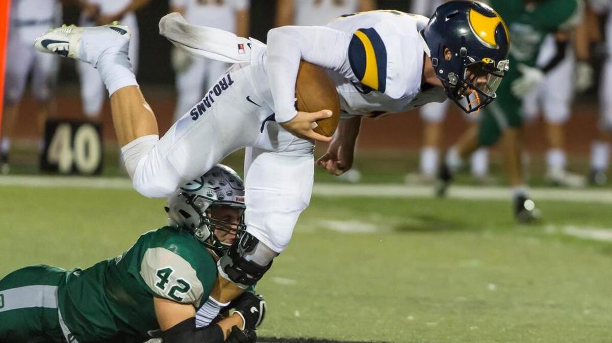 Granite Bay Grizzlies Ryan Macintosh (42), tackles Oak Ridge Trojan quarterback Ian Book (11) during the fourth quarter as the Granite Bay Grizzlies host the Oak Ridge Trojans, Friday, October 9, 2015. The Oak Ridge Trojans won the game 36-28.