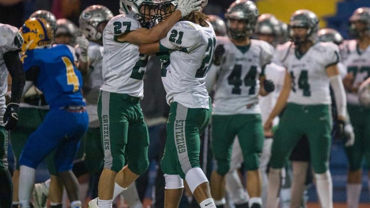 Granite Bay Grizzlies running back Isaiah Lewis (21) celebrates with Granite Bay Grizzlies strong safety Sam Cusano (27) after Lewis got an interception during the fourth quarter that ultimately sealed the Grizzlies’ victory against the Grant High School Pacers during the CIF Sac-Joaquin Section Division II football playoffs at Grant High School in Sacramento, on Saturday, Nov. 21, 2015.