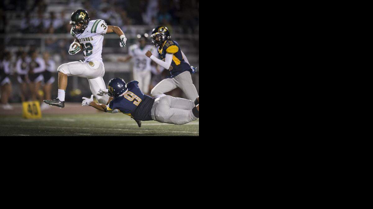 
Monterey Trail's Trey Nahhas (32) evades C.J. Garmon (9) of Inderkum High School as he makes his way to the endzone during the first half at Inderkum on Sept. 6, 2014.
