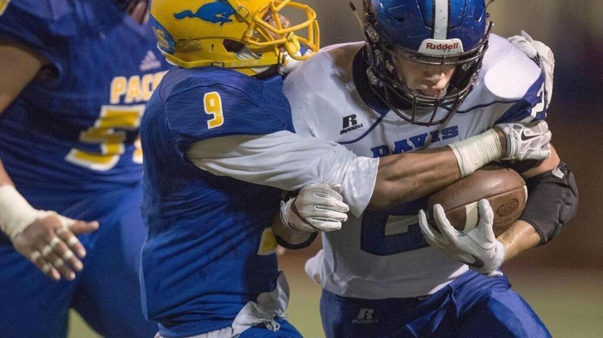 Pacers Cody Brown (9) wraps up Blue Devils running back Ethan Iacono (21) during the game between the Grant Pacers and the Davis Blue Devils at Grant High School in Sacramento on Friday, Oct. 28, 2016.