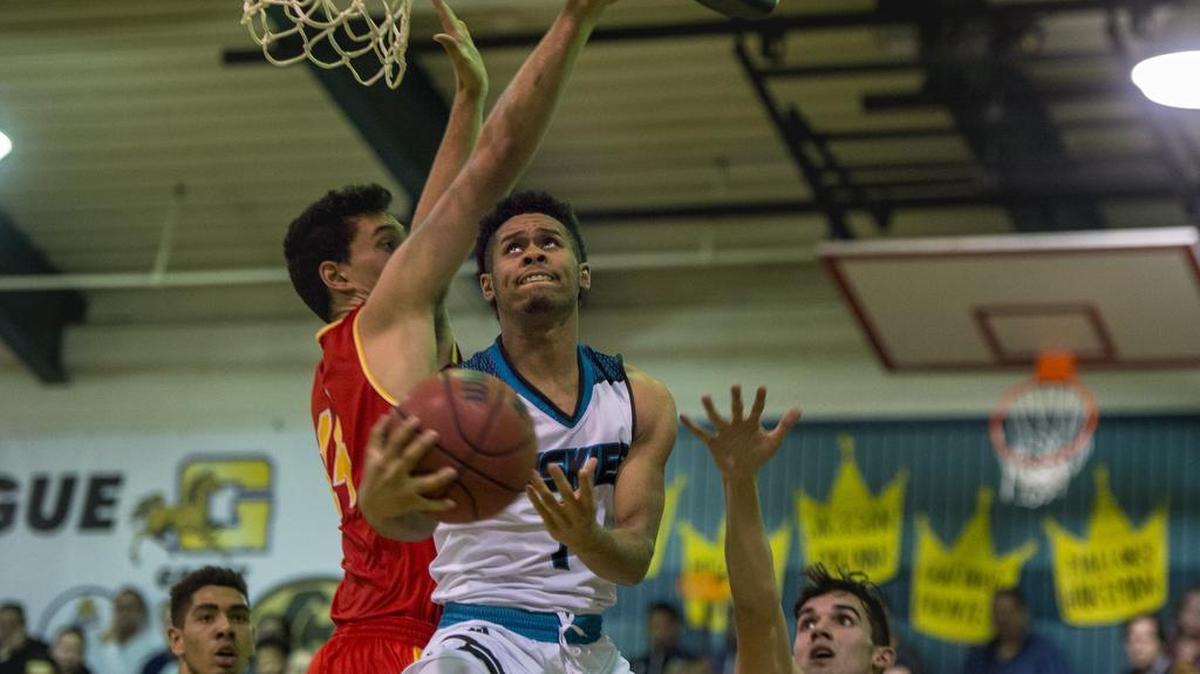 Sheldon Huskies guard Dom Johnson (1) gets between Jesuit Marauders Darin Similai (14) and Chris Simpson (10) for a layup.