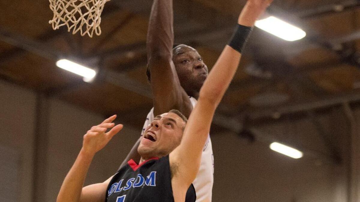 Sacramento High School forward Solomon Young, rear, blocks a shot by Folsom guard Jordan Ford in the fourth quarter on Friday in Oak Park.