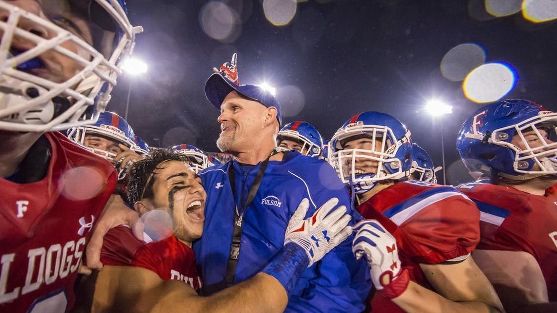 Folsom Bulldogs head coach Kris Richardson celebrates with his team after their 49-42 win over the Helix Highlanders in the CIF Division I-AA state title game, at Hornet Stadium Saturday.