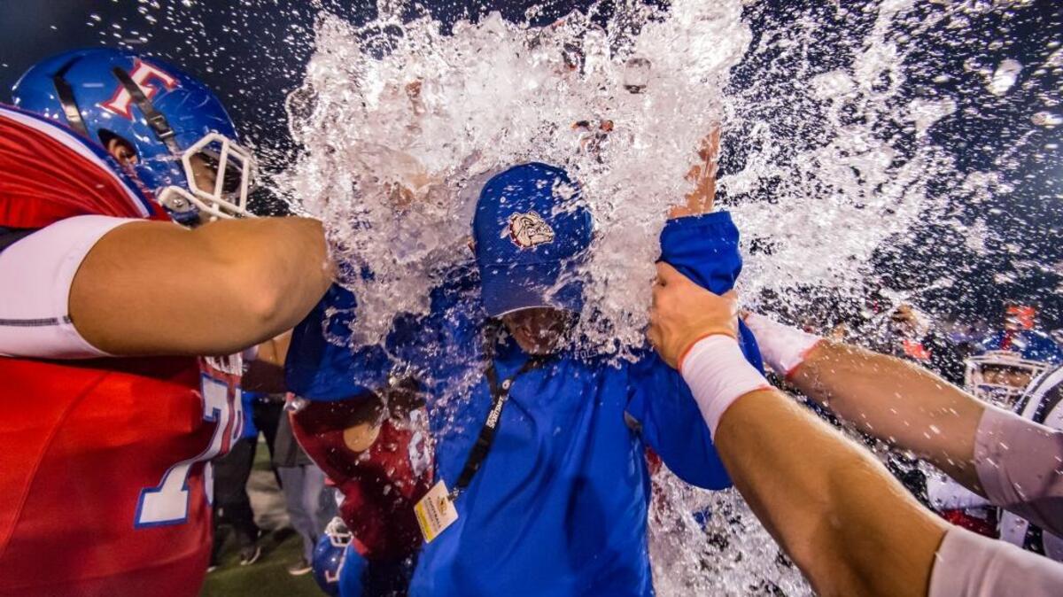 Folsom football coach Kris Richardson is doused after the Bulldogs beat Helix for the CIF State Division I-AA title Friday at Sacramento State.