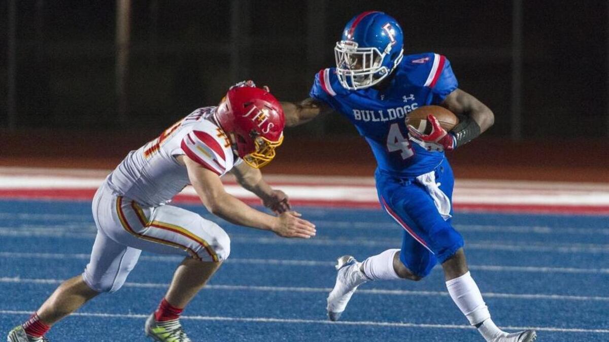 Folsom’s Daniyel Ngata (4) fends off Jesuit’s Maxwell Sackett with a stiff arm in a Sac-Joaquin Section Division I semifinal on Friday.