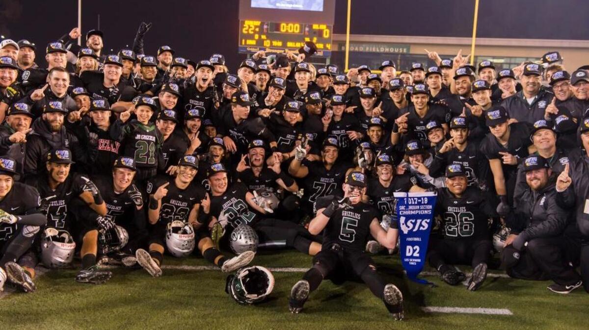 Granite Bay players celebrate their Sac-Joaquin Section Division II championship Saturday at Sacramento State. With blue banner in hand, the Grizzlies head into the NorCal regional title game.