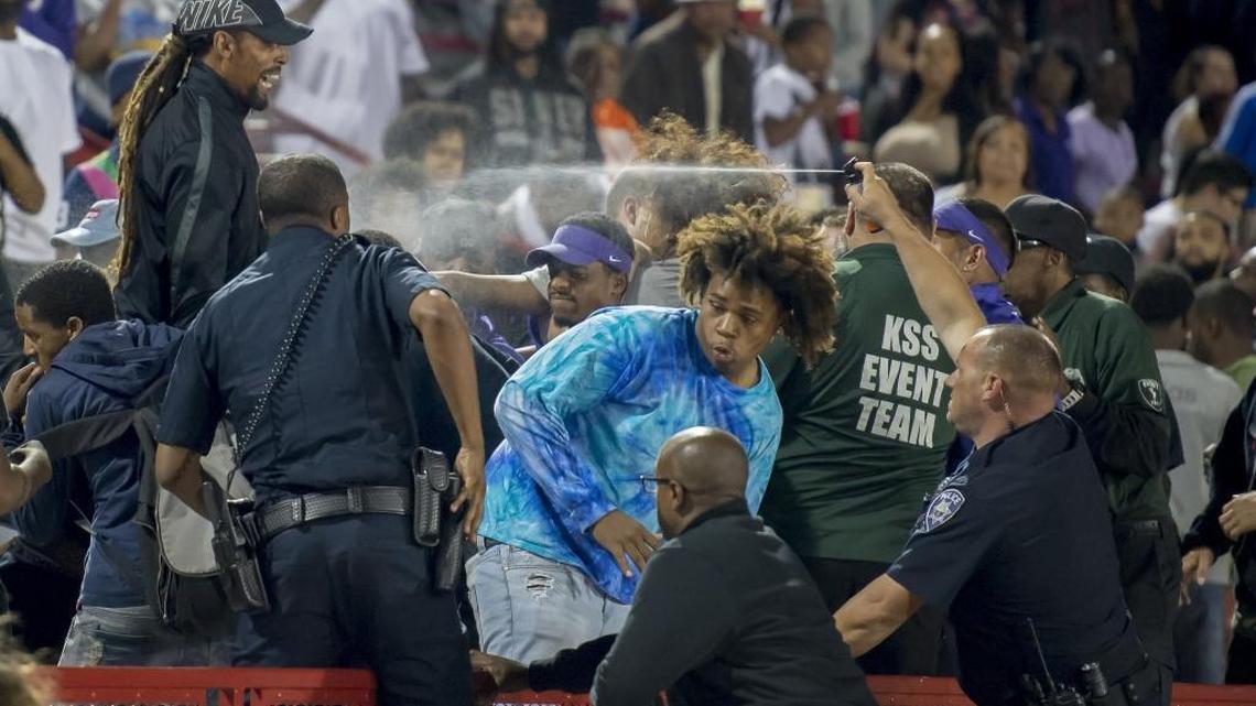 A police officer uses pepper spray to break up a fight in the stands during the second quarter as the Sacramento Dragons hosted the Folsom Bulldogs at Hughes Stadium at Sacramento City College on Friday.