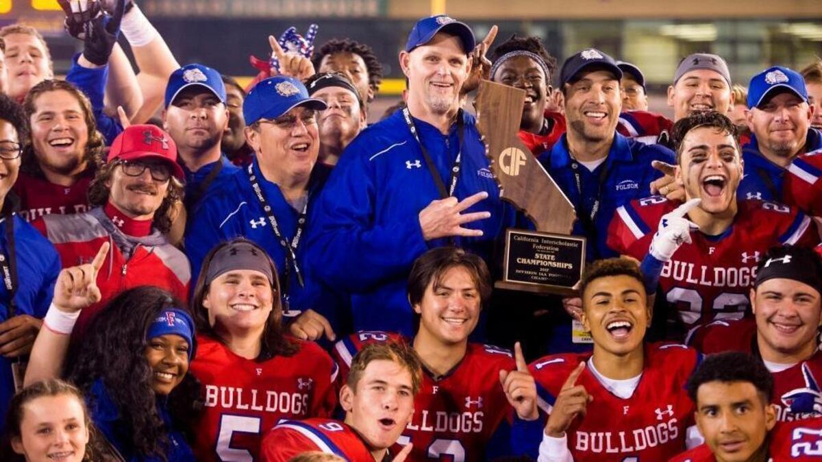Folsom coach Kris Richardson celebrates with his team after their 49-42 win over Helix of La Mesa in the CIF Division I-AA state title game at Hornet Stadium at Sacramento State on Friday.