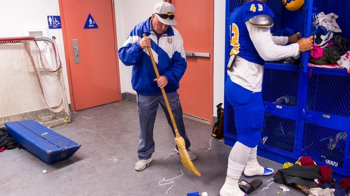 Grant coach Mike Alberghini sweeps up trash in the locker room before the Pacer’s home game against the Sheldon Huskies on Friday.