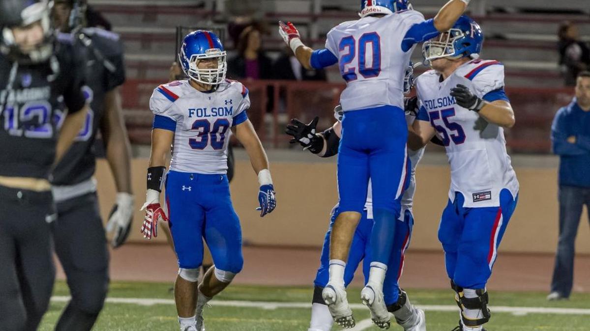 Folsom’s Dylan Jorge (20) celebrates his interception and touchdown during Friday’s game against Sacramento at Hughes Stadium.