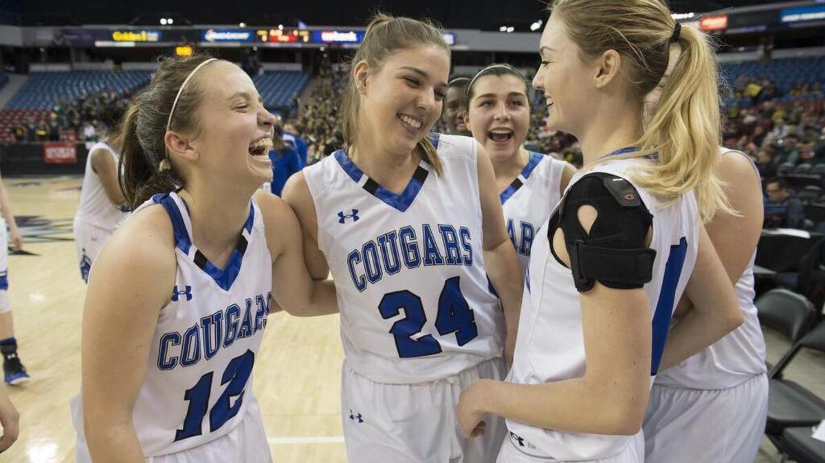 Capital Christian's Michaela Mahnke (12), Ashtyn Butler (24) and other teammates enjoy the moment following the victory in the Sac-Joaquin Section Girls Division V final playoff game between the Capital Christian Cougars and the Argonaut Mustangs at Sleep Train Arena in Sacramento, March 4, 2016.