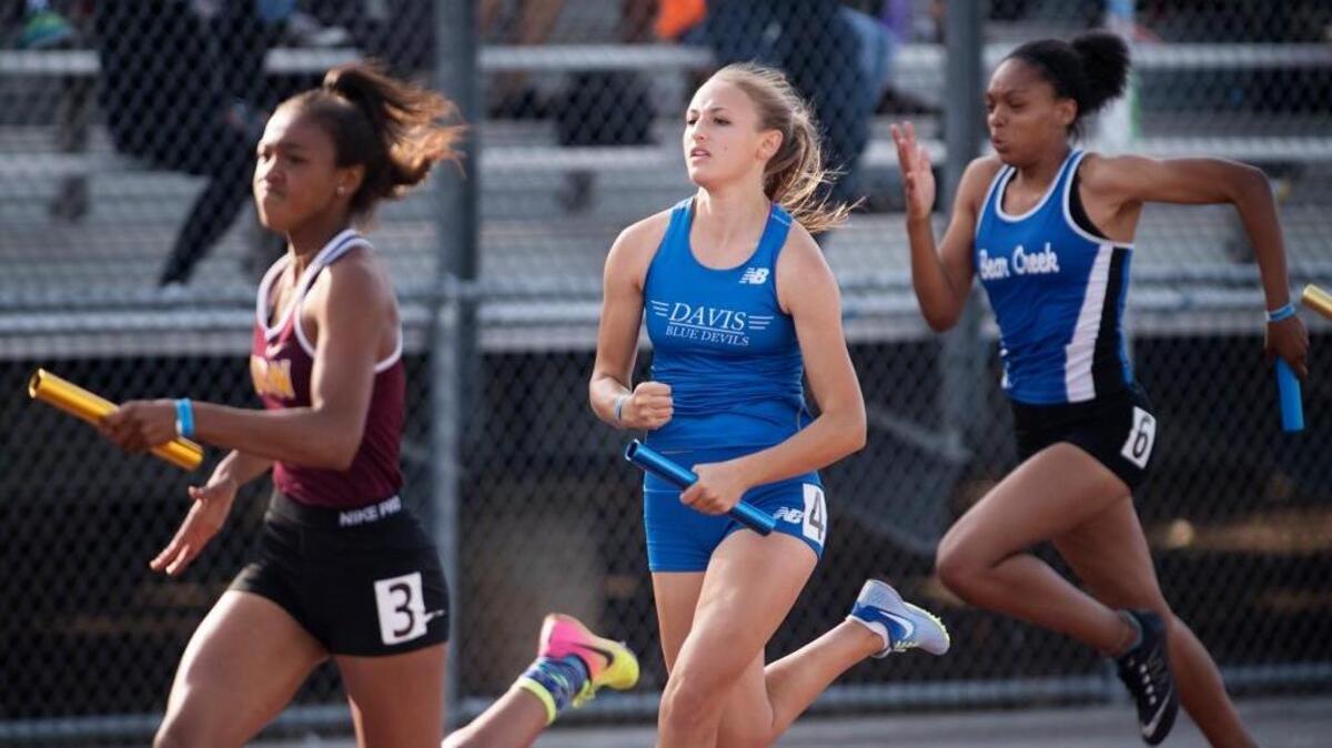 Davis anchor leg runner Brooke Rubinstein, center, passes Edison's Deja Hudson on the anchor leg of the 4x100 race to win with a time of 47.39 during the Sac-Joaquin Section Masters Meet in Elk Grove on Friday.