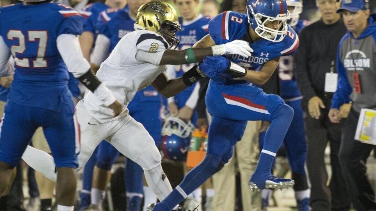 Elk Grove’s Julius Fullah, left, tries to tackle Folsom’s Drake Stallworth during the Sac-Joaquin Section Division I championship game in Sacramento on Saturday, December 5, 2015. Stallworth caught four touchdown passes last week.