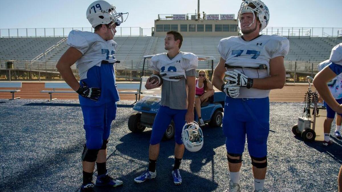 Folsom quarterback Jake Jeffrey, talks with Jonah Williams, right and Kooper Richardson, left, during practice at Folsom High School on Sept. 21, 2015.