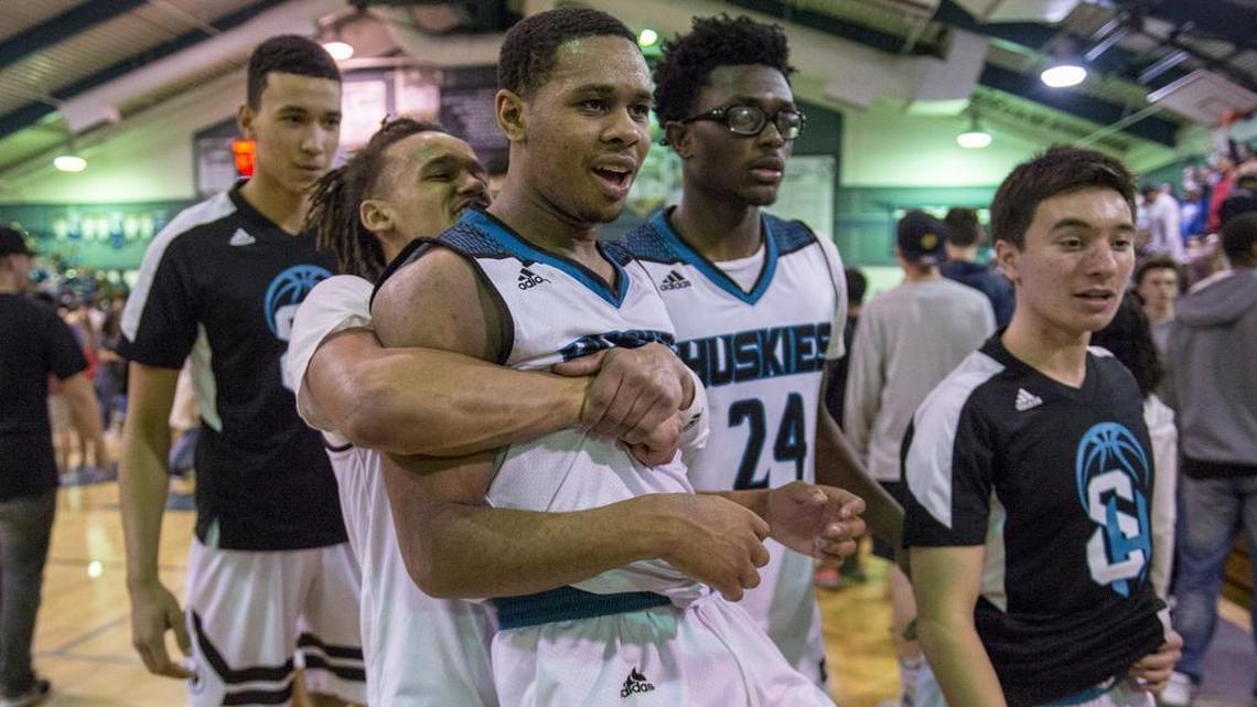 Sheldon Huskies guard Dale Currie (0) embraces teammate Dom Johnson (1) after the Huskies made up a double-digit halftime deficit to beat the Memorial of Fresno 67-65 on Friday.