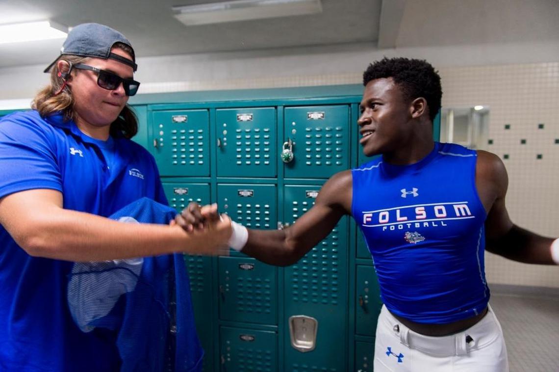 Kaden Richardson, left, is greeted by Daniyel Ngata before Folsom faced Granite Bay on Sept. 29.