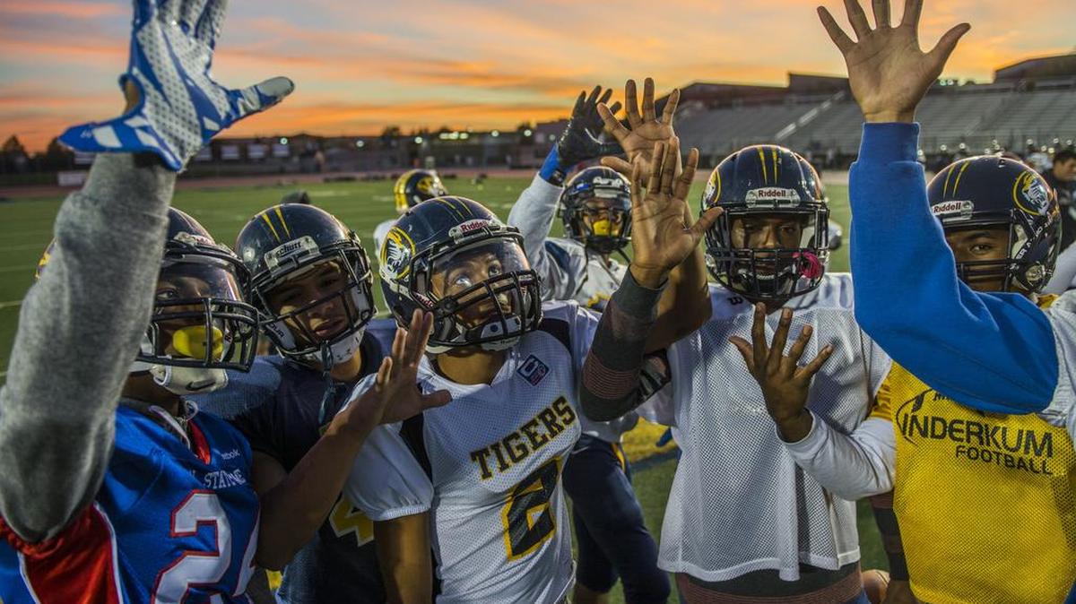 Inderkum High School senior running back Jimmie Johnson (2), cousin of slain Grant High School athlete Jaulon Clavo, and teammates raise five fingers to the sky in honor of Clavo's number five jersey during practice at Inderkum High School on Tuesday, Nov. 18, 2015, in Sacramento.