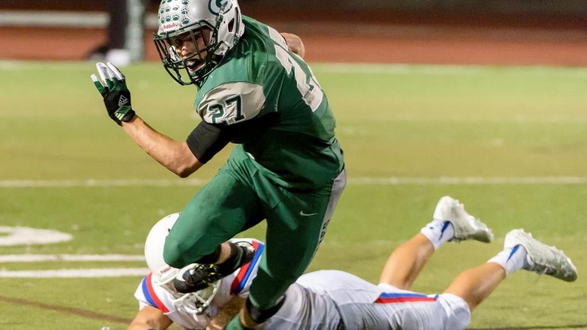 Granite Bay High’s Sam Cusano tries to elude a tackler during the third quarter as the Grizzlies host the Folsom Bulldogs on Friday, Sept. 25, 2015.