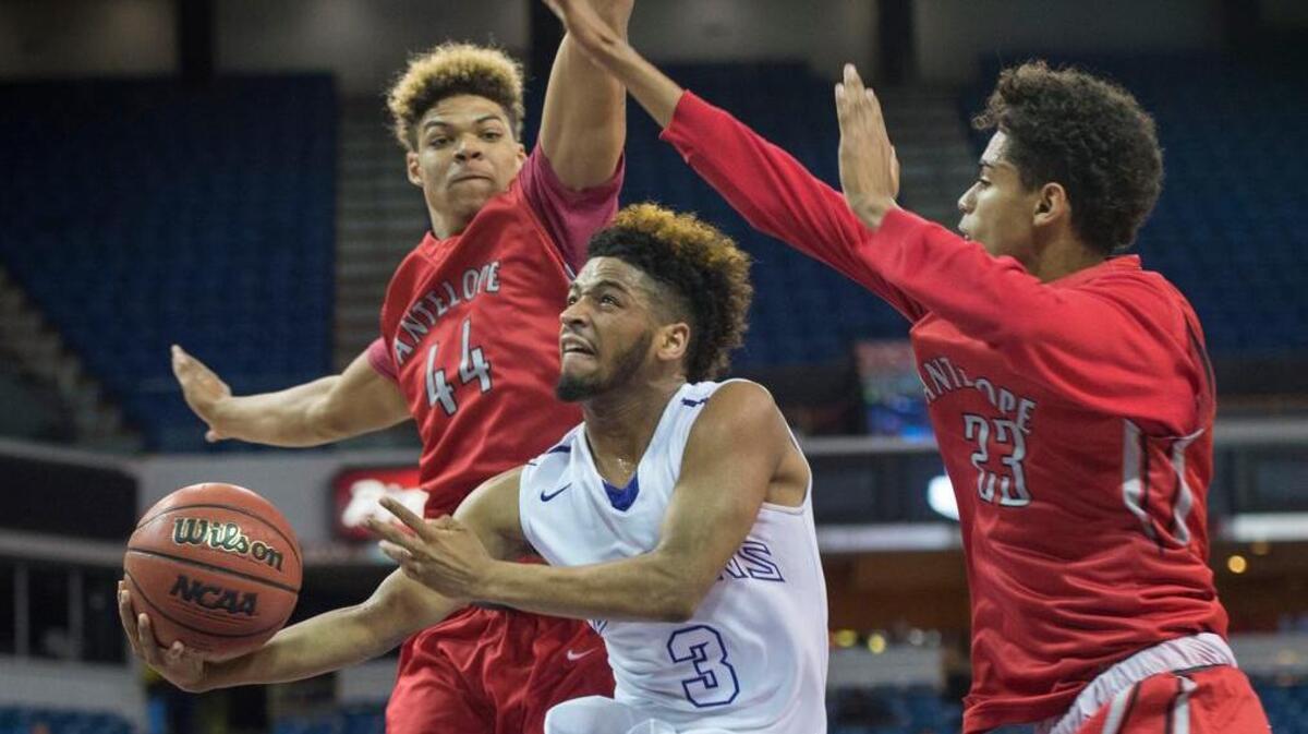 Sacramento High guard Sayvon Hines shoots between Antelope’s Montel Aaron (44) and Morgan Walser in the Sac-Joaquin Section Division II final at Sleep Train Arena.