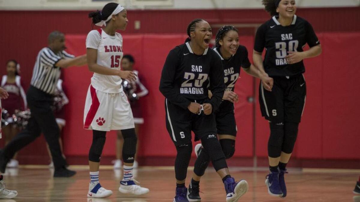 Sacramento Dragons guard RyAnne Walters (23), Sasha Brown (22) and Maya Lawrence (30) begin to celebrate following their 54-48 victory over Sacramento on Wednesday at McClatchy High School in Sacramento.