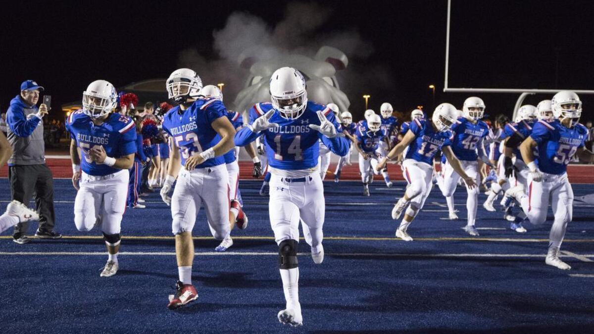 The Folsom High School Bulldogs come onto the field before the game as the Folsom High School Bulldogs varsity football team host the Oak Ridge High School Trojans, Friday, Nov. 4, 2016.