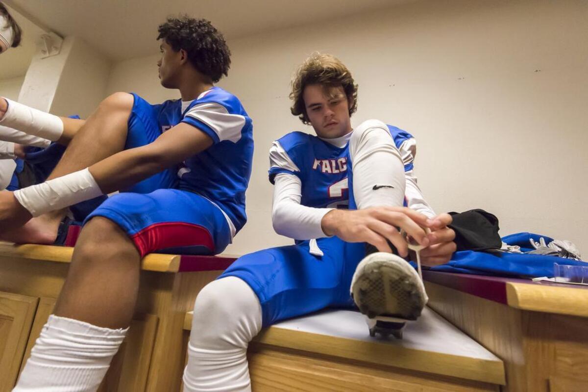 Christian Brothers Falcons Gunnor Faulk, (2), tapes his shoes before the game as the Christian Brothers Falcons, host the Bencia Panthers in the Sac-Joaquin Section Division III playoff opener at Hughes Stadium, Friday Nov 10, 2017.