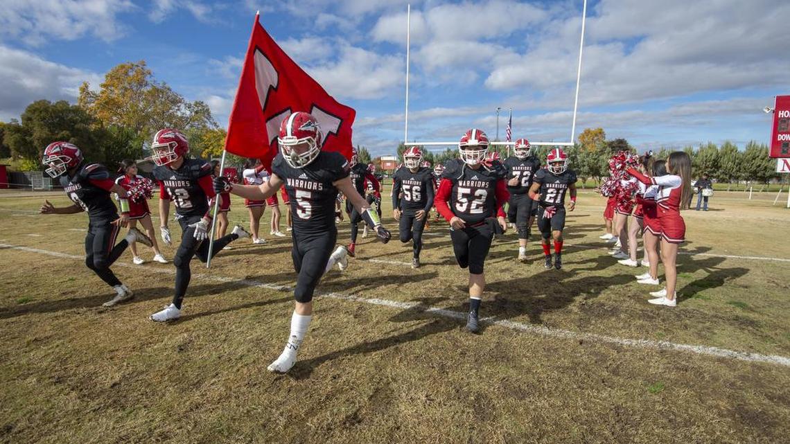 The Winters High School Warriors come on the to the field before the game.