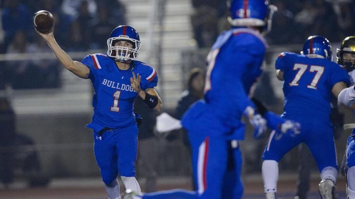Bulldogs Joe Curry (1) throws the ball to Bulldogs Eric Davis (21) during the Sac-Joaquin Section Division I semifinal game between the Folsom Bulldogs and the Elk Grove Thundering Herd at Folsom High School in Folsom on Friday, November 25, 2016.