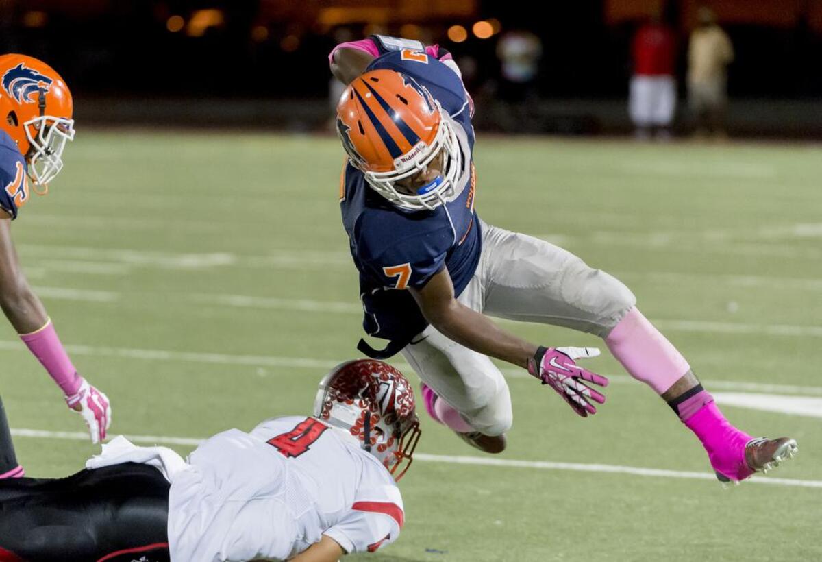 Antelope Titan’s Garrett Chapman (4) trips up Cosumnes Oaks’ Christian McFarland (7) after his catch in 2015.