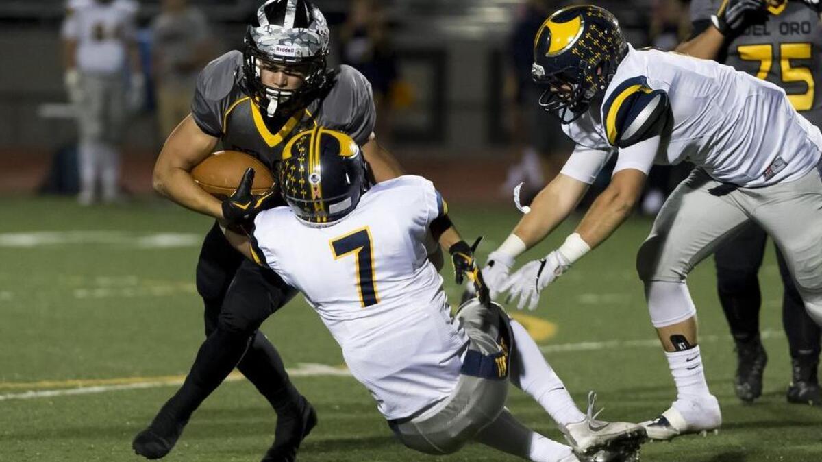 Del Oro Golden Eagles Dalton Gee (5) runs with the ball and is tackled by Oak Ridge Trojans Truman Andrus (7) during the first quarter, Friday, Oct. 21, 2016.
