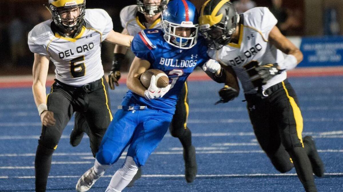
Folsom Bulldogs' Jack Sa (3) runs with the ball flanked by Del Oro Golden Eagles' Connor Lehner (6) and Trey Udoffia (3) in the fourth quarter, as the Folsom Bulldogs host the Del Oro Golden Eagles on Friday, October 2, 2015. 
