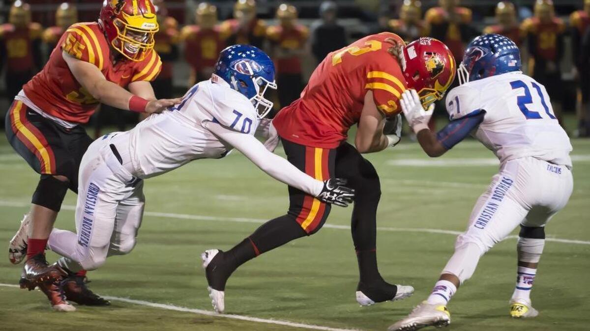 Christian Brothers High School Falcons Sam Tanberg (20), tackle Oakdale Mustangs William Semone (2), during the first quarter as the Christian Brothers High School Falcons face the Oakdale Mustangs in the Sac-Joaquin Section Division III championship football game at Lincoln High School in Stockton, Friday Dec. 2, 2016.