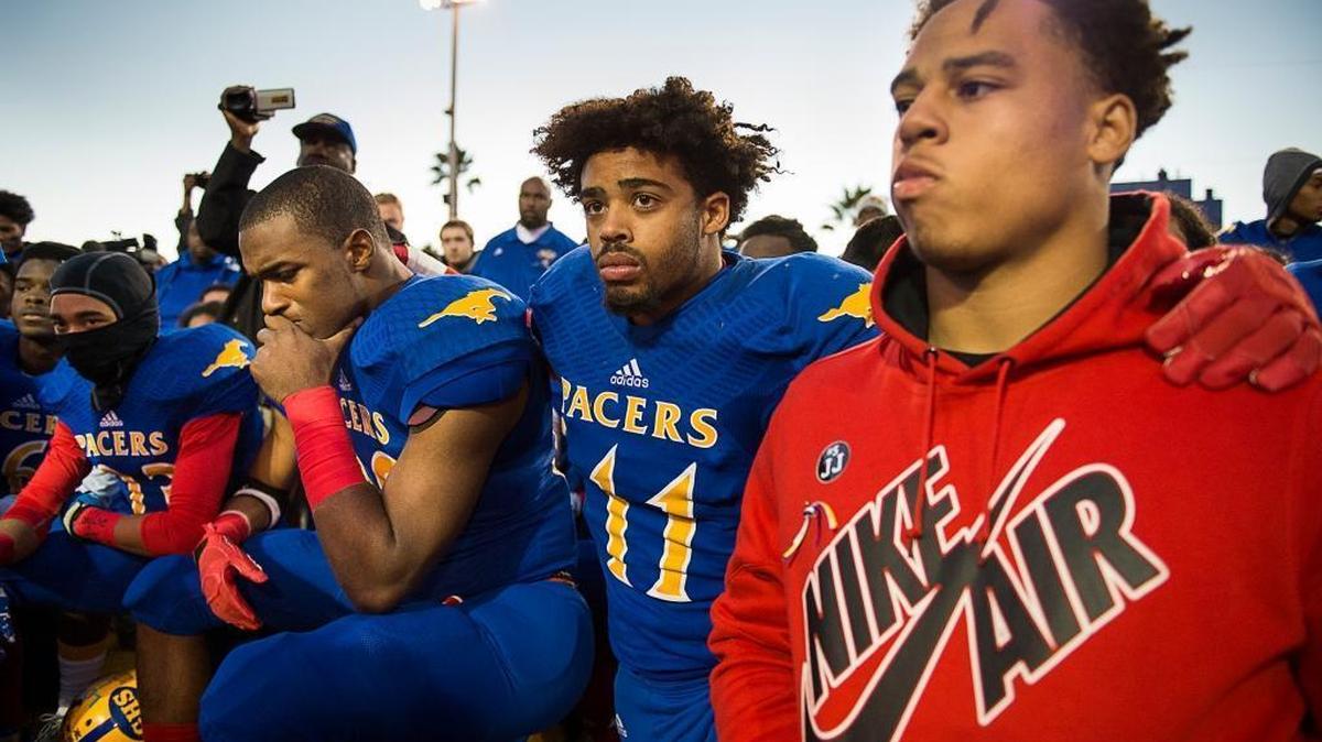 Elijah Orr (11) hugs teammates during a remembrance of teammate, Jaulon, during a pregame ceremony for her son at Grant High School Monday November 16, 2015 in Sacramento, Calif. Grant High School football player Jaulon Clavo died during the shooting during an off campus trip to get food before the game last week.