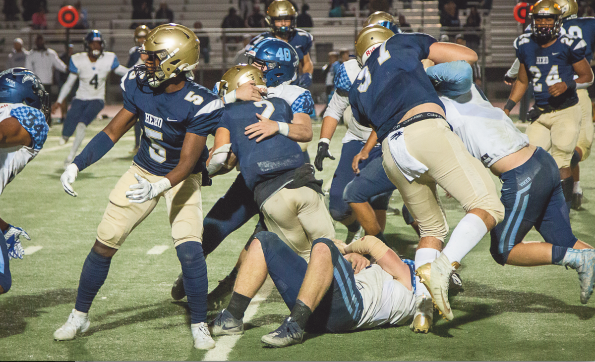 Elk Grove players say instances like this one, where quarterback Carter Harris has his legs wrapped up by an Oakmont defender, sparked a fight Friday night.