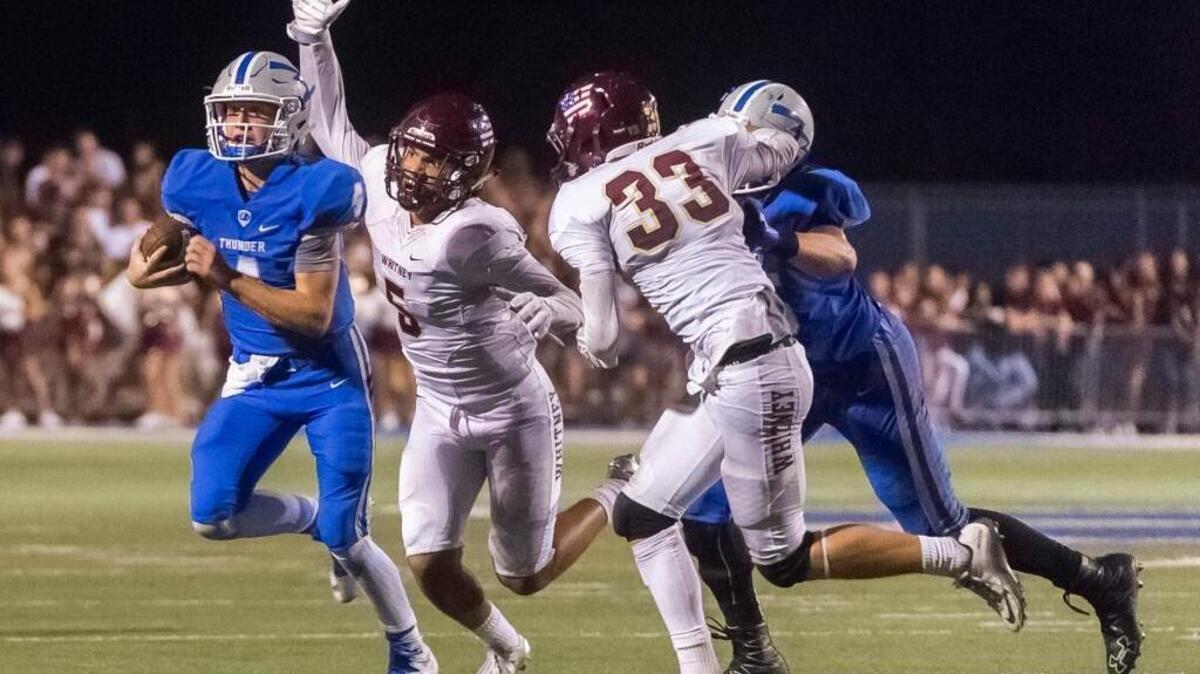 Rocklin quarterback Cade Wyant, left, is chased by Whitney during last season’s Quarry Bowl. Wyant scored two touchdowns in Friday’s game against Whitney.