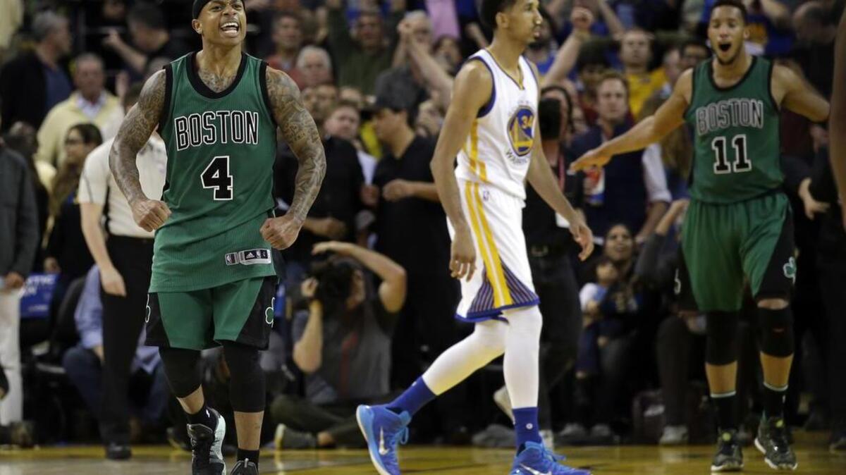 Boston’s Isaiah Thomas and Evan Turner celebrate as Golden State’s Shaun Livingston walks off the court after the Celtics’ 109-106 victory over the Warriors on Friday, April 1, 2016, in Oakland.