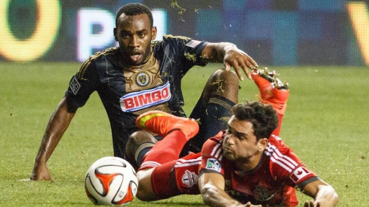 Philadelphia Union’s Amobi Okugo, left, gets tangled with Toronto FC’s Gilberto during a Major League Soccer match in 2014. Okugo, who attended Sacramento-area high schools, has a website aimed at helping athletes manage their money.