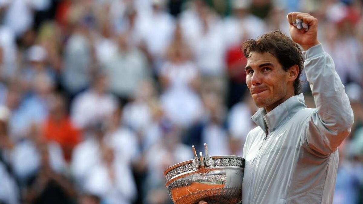 Rafael Nadal acknowledges the crowd while holding the trophy after winning the final of the French Open tennis tournament against Novak Djokovic at Roland Garros in Paris. Nadal has won this event a record nine times.