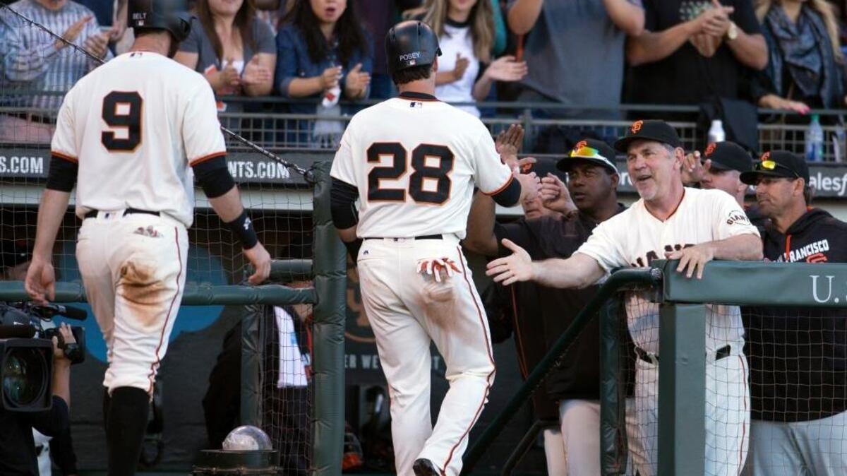 San Francisco Giants manager Bruce Bochy extends a handshake to Brandon Belt (9) and Buster Posey (28) after they both scored on Brandon Crawford’s double against the Arizona Diamondbacks duringf a baseball game on Sunday, July 10, 2016, in San Francisco. The Giants reached the All-Star break with the best record in the majors – 57-33.