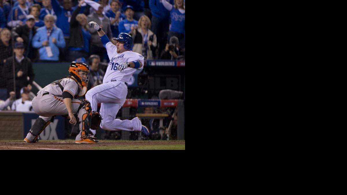 
Royals Billy Butler slides past Giant Buster Posey, scoring from first base on a Alex Gordon double in the second inning in Game 7 of the World Series at Kauffman Stadium in Kansas City, Mo on Wednesday, Oct. 29, 2014. 
