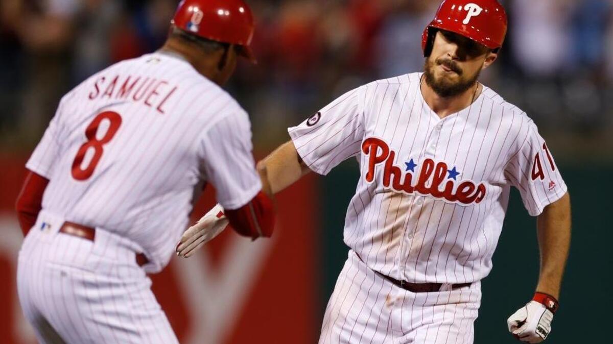 Philadelphia Phillies first baseman Brock Stassi, right, is congratulated by third base coach Juan Samuel after hitting a home run against the New York Mets on Monday in Philadelphia. It was the first hit of his career.