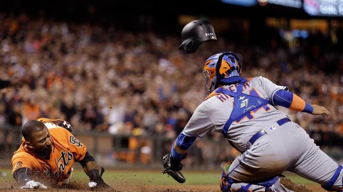 The San Francisco Giants’ Eduardo Nunez, left, slides to score past New York Mets catcher Rene Rivera during a baseball game Friday, Aug. 19, 2016, in San Francisco. The teams meet Wednesday in a National League wild-card elimination game.