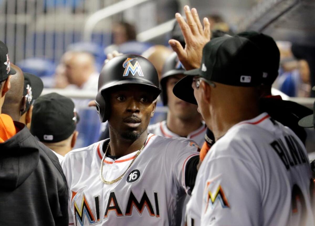 Miami Marlins’ Dee Gordon is congratulated in the dugout Friday in Miami.
