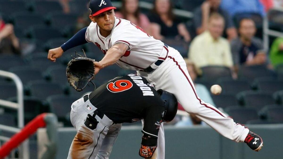 Atlanta Braves third baseman Rio Ruiz, top, reaches for a ball as the Miami Marlins’ Dee Gordon slides in safely Thursday in Atlanta.